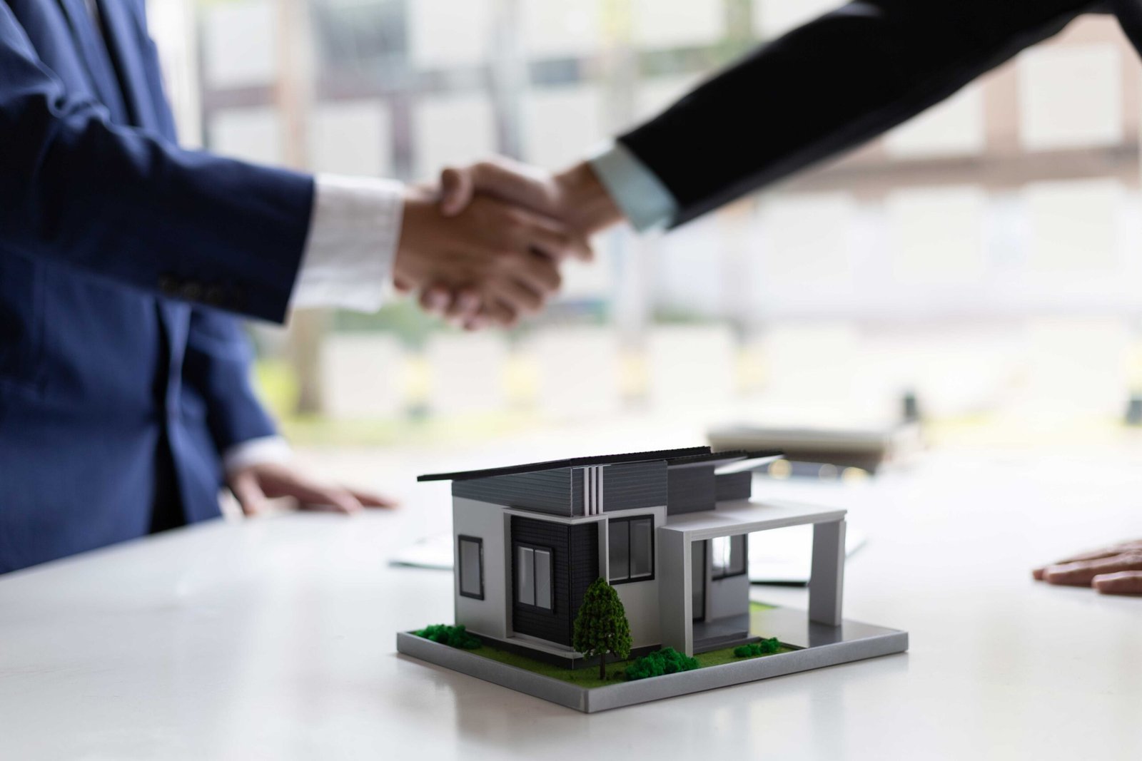 Foto de agente inmobiliario y cliente cerrando un trato o acuerdo